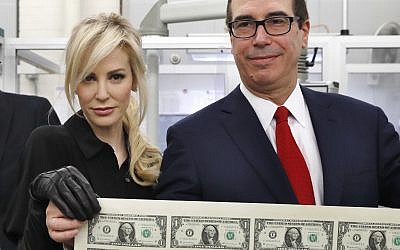Treasury Secretary Steven Mnuchin, (r), and his wife Louise Linton, hold up a sheet of new $1 bills, the first currency notes bearing his and US Treasurer Jovita Carranza's signatures, November 15, 2017, at the Bureau of Engraving and Printing (BEP) in Washington. (AP Photo/Jacquelyn Martin)