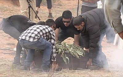 In this image made from video, the remains of the 42,000-year-old "Mungo Man" are unloaded and placed on the ground during a traditional ceremony in Lake Mungo, Australia, Friday, Nov. 17, 2017. (Australian Broadcasting Corporation via AP)