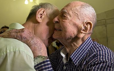 Holocaust survivor Eliahu Pietruszka, right, embraces his nephew Alexandre Pietruszka as they meet for the first time in Kfar Saba, Israel, November 16, 2017. (AP/Sebastian Scheiner)