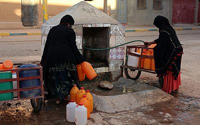 Moroccan women filling up containers with water from a hose, in Zagora, southeastern Morocco, October 9, 2017. (AP Photo/Issam Oukhouya, File)
