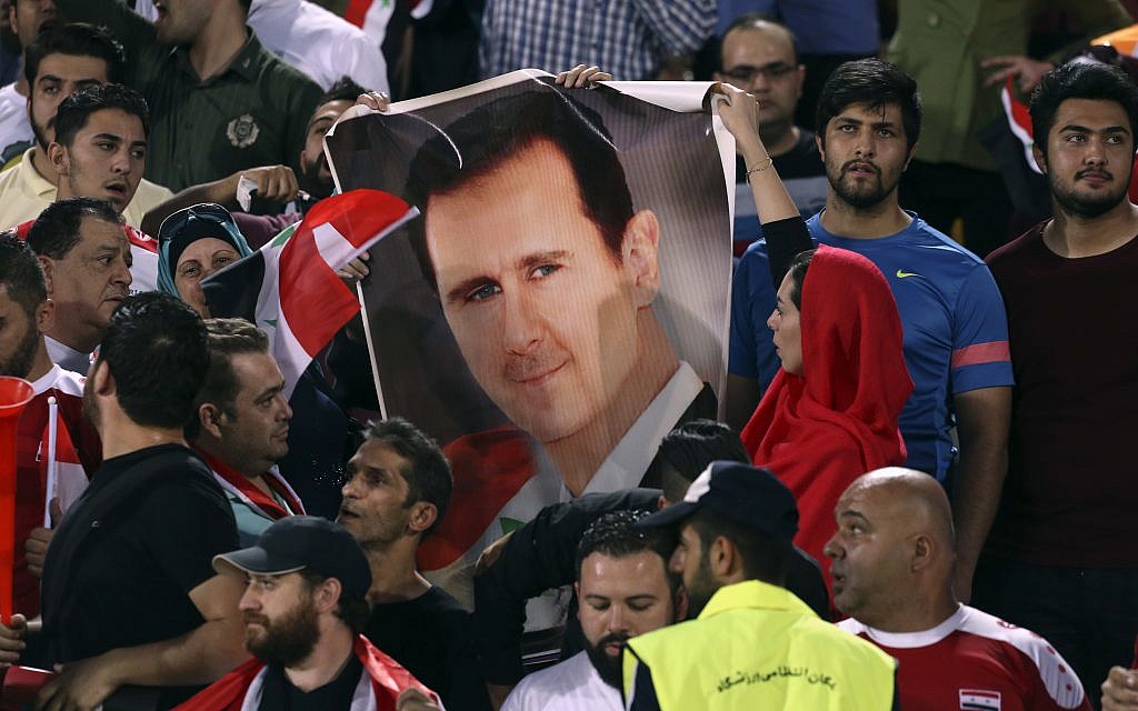Syrian soccer fans hold a portrait of their president, Bashar Assad, before their match with Iran during a Round 3 - Group A World Cup qualifier at the Azadi Stadium in Tehran, Iran, September 5, 2017. (AP Photo/Vahid Salemi) Syrian soccer fans hold a portrait of their president, Bashar Assad, before their match with Iran during a Round 3 - Group A World Cup qualifier at the Azadi Stadium in Tehran, Iran, September 5, 2017. (AP Photo/Vahid Salemi)