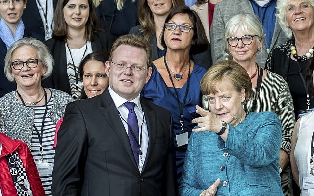 In This May 17, 2017 file photo, German Chancellor Angela Merkel talks to the mayor of the western German town of Altona, Andreas Hollstein, center, during the award ceremony for the German national integration prize. (Michael Kappeler/dpa via AP) In This May 17, 2017 file photo, German Chancellor Angela Merkel talks to the mayor of the western German town of Altona, Andreas Hollstein, center, during the award ceremony for the German national integration prize. (Michael Kappeler/dpa via AP)