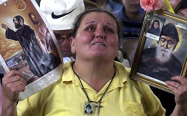 Mary Iskandar, 50, a Lebanese housewife, is overcome by emotion, as she raises a picture of Maronite Naamatallah Kassab Hardini, left, and St. Charbel Makhlouf, Lebanon's first Maronite cleric to be canonized by the Vatican, in 1977, as Pope John Paul II, proclaims Hardini a saint of the Catholic Church at a ceremony at the Vatican on May 16, 2004. (AP Photo/Mahmoud Tawil) Mary Iskandar, 50, a Lebanese housewife, is overcome by emotion, as she raises a picture of Maronite Naamatallah Kassab Hardini, left, and St. Charbel Makhlouf, Lebanon's first Maronite cleric to be canonized by the Vatican, in 1977, as Pope John Paul II, proclaims Hardini a saint of the Catholic Church at a ceremony at the Vatican on May 16, 2004. (AP Photo/Mahmoud Tawil)