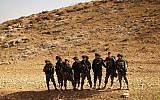 Soldiers smile after 'conquering' a hill as part of a training exercise in the Jordan Valley on November 28, 2017. (Judah Ari Gross/Times of Israel)