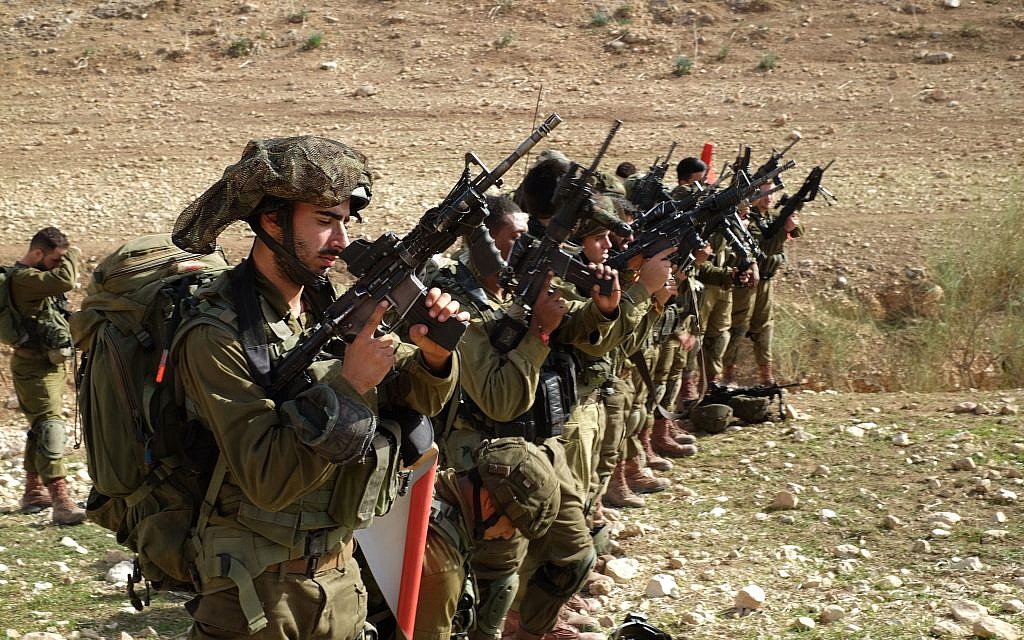 Soldiers check their weapons to make sure they are empty following a training exercise in the Jordan Valley on November 28, 2017. (Judah Ari Gross/Times of Israel)