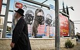 An ultra-Orthodox Jewish man walks past a billboard that was vandalized, near the entrance to Jerusalem, November 2, 2017. (Noam Revkin Fenton/Flash90/File)