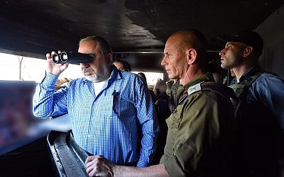 Defense Minister Avigdor Liberman looking through binoculars during a visit to the Israel's northern border, November 14, 2017. Ariel Hermoni/Ministry of Defense)