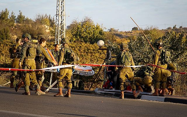 Illustrative: Israeli security and medical personnel evacuate a wounded Palestinian terrorist at the scene of ramming and stabbing attack near the Gush Etzion Junction on November 17, 2017. (Gershon Elinson/Flash90) Illustrative: Israeli security and medical personnel evacuate a wounded Palestinian terrorist at the scene of ramming and stabbing attack near the Gush Etzion Junction on November 17, 2017. (Gershon Elinson/Flash90)