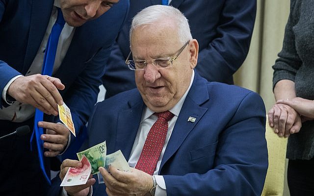 President Reuven Rivlin looks at the new NIS 20 and NIS 100 bills at a ceremony in his residence in Jerusalem on November 22, 2017. (Yonatan Sindel/Flash90) President Reuven Rivlin looks at the new NIS 20 and NIS 100 bills at a ceremony in his residence in Jerusalem on November 22, 2017. (Yonatan Sindel/Flash90)