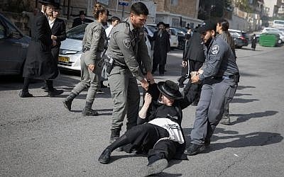 Ultra-Orthodox Jewish men clash with police during a protest against the arrest of a religious seminary student who failed to comply with a recruitment order, next to the army draft office in Jerusalem, November 28, 2017. (Flash90)