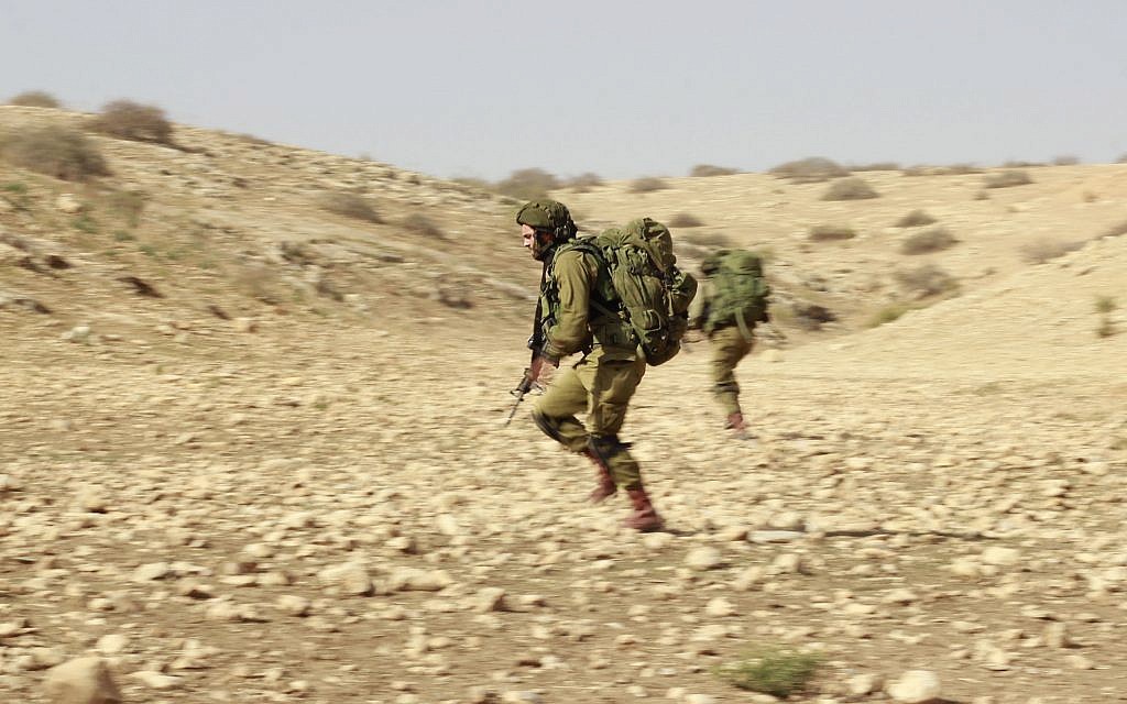 A soldier from the IDF's Kfir Brigade runs to capture a hill during a training exercise in the Jordan Valley on November 28, 2017. (Judah Ari Gross/Times of Israel)