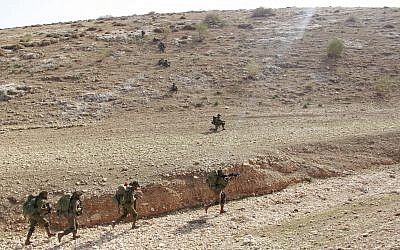 Soldiers from the IDF's Kfir Brigade run into a valley in order to destroy a simulated rocket launcher during a training exercise in the Jordan Valley on November 28, 2017. (Judah Ari Gross/Times of Israel)
