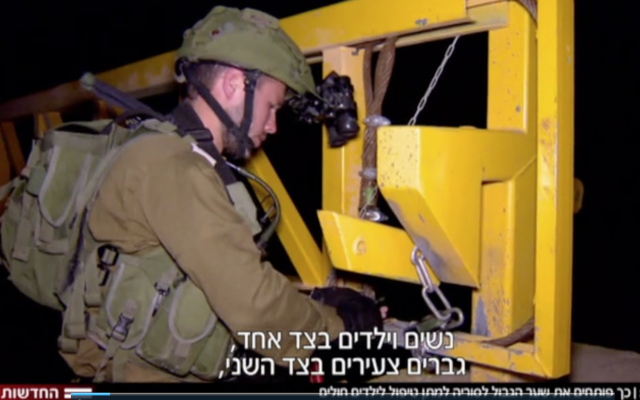 Israeli soldiers open a gate at the Syrian border ahead of the entry of a group of Syrian mothers and children for medical treatment, November 2017 (Hadashot TV screenshot)