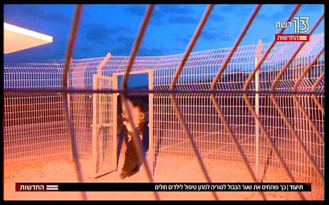A Syrian mother, carrying her young child, crosses the border into Israel, in a TV report broadcast on November 19, 2017. (Hadashot News screenshot)