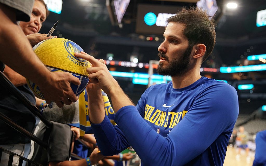 Omri Casspi signs a basketball for a Golden State Warriors fan. (Courtesy Golden State Warriors;NBAE/Getty Images) Omri Casspi signs a basketball for a Golden State Warriors fan. (Courtesy Golden State Warriors;NBAE/Getty Images)