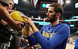 Omri Casspi signs a basketball for a Golden State Warriors fan. (Courtesy Golden State Warriors;NBAE/Getty Images)
