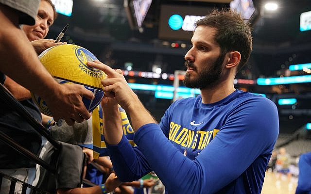 Omri Casspi signs a basketball for a Golden State Warriors fan. (Courtesy Golden State Warriors;NBAE/Getty Images) Omri Casspi signs a basketball for a Golden State Warriors fan. (Courtesy Golden State Warriors;NBAE/Getty Images)