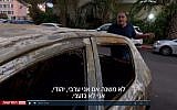 Yoram Israeli stands next to his torched car in Netanya on November 3, 2017. (Screen capture Channel 2)