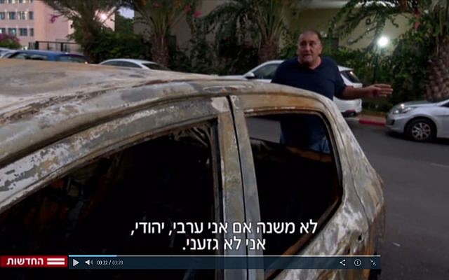 Yoram Israeli stands next to his torched car in Netanya on November 3, 2017. (Screen capture Channel 2) Yoram Israeli stands next to his torched car in Netanya on November 3, 2017. (Screen capture Channel 2)