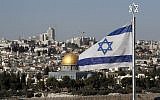 The Israeli flag flutters in front of the Old City of Jerusalem's Dome of the Rock on December 1, 2017. (AFP Photo/Thomas)