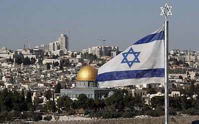 The Israeli flag flutters in front of the Old City of Jerusalem's Dome of the Rock on December 1, 2017. (AFP Photo/Thomas)