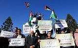 Palestinians wave the national flag during a demonstration in Gaza City on December 3, 2017, in support of the reconciliation talks between Hamas and Fatah. (AFP/Mohammed Abed)