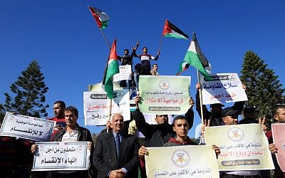 Palestinians wave the national flag during a demonstration in Gaza City on December 3, 2017, in support of the reconciliation talks between Hamas and Fatah. (AFP/Mohammed Abed)