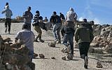 Protesters carry a Palestinian injured in clashes with IDF soldiers at the entrance to the northern West Bank village of Qusra on December 4, 2017 (AFP Photo/Jaafar Ashtiyeh)