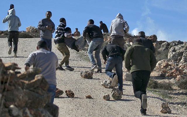 Protesters carry a Palestinian injured in clashes with IDF soldiers at the entrance to the northern West Bank village of Qusra on December 4, 2017 (AFP Photo/Jaafar Ashtiyeh) Protesters carry a Palestinian injured in clashes with IDF soldiers at the entrance to the northern West Bank village of Qusra on December 4, 2017 (AFP Photo/Jaafar Ashtiyeh)