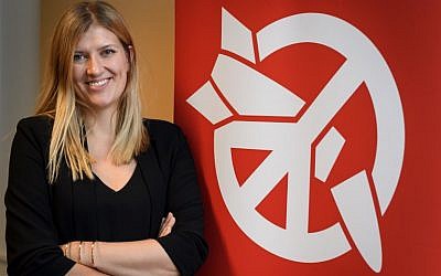 Beatrice Fihn, executive director of 2017 Nobel Peace Prize-winning International Campaign to Abolish Nuclear Weapons (ICAN), poses next to the ICAN logo at their headquarters during an interview with AFP on November 30, 2017 in Geneva. (AFP/Fabrice COFFRINI)