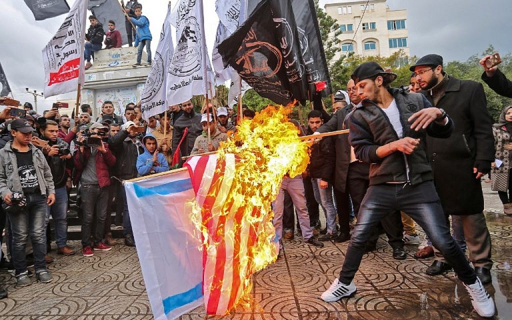 Palestinian protesters burn the US and Israeli flags in Gaza City on December 6, 2017, ahead of US President Donald Trump's speech regarding Jerusalem. (AFP PHOTO / MAHMUD HAMS)