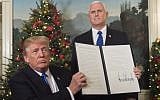 US President Donald Trump holds up a signed memorandum recognizing Jerusalem as Israel's capital, as US Vice President looks on, at the White House, on December 6, 2017. (AFP Photo/Saul Loeb)