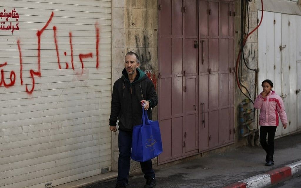 A man and a child walk past closed shops in Jerusalem as a general strike was called following US President Donald Trump's decision to recognise Jerusalem as the capital of Israel, on December 7, 2017 in east Jerusalem.  / AFP PHOTO / AHMAD GHARABLI