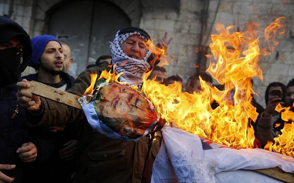 Palestinian protesters burn an effigy of US President Donald Trump following his decision to recognize Jerusalem as the capital of Israel, in the West Bank city of Nablus, on December 7, 2017.  (AFP PHOTO / Jaafar ASHTIYEH)
