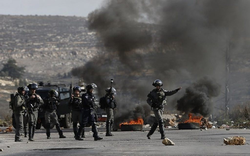 Israeli forces take position during clashes with Palestinian protesters in the West Bank village of Betunia near Ramallah on December 7, 2017. (AFP PHOTO / ABBAS MOMANI)