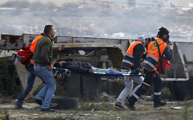 Palestinian emergency services evacuate a protestor wounded in clashes with Israeli troops following a demonstration against US President Donald Trump's decision to recognize Jerusalem as the capital of Israel, near the Jewish settlement of Beit El near the West Bank city of Ramallah, on December 7, 2017. (AFP Photo/Abbas Momani) Palestinian emergency services evacuate a protestor wounded in clashes with Israeli troops following a demonstration against US President Donald Trump's decision to recognize Jerusalem as the capital of Israel, near the Jewish settlement of Beit El near the West Bank city of Ramallah, on December 7, 2017. (AFP Photo/Abbas Momani)