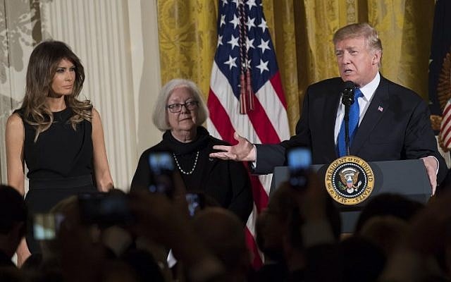 US President Donald Trump speaks alongside First Lady Melania Trump (L), and Holocaust survivor Louise Lawrence-Israels (C) during a Hanukkah reception in the East Room of the White House in Washington, DC, December 7, 2017. (AFP PHOTO / SAUL LOEB) US President Donald Trump speaks alongside First Lady Melania Trump (L), and Holocaust survivor Louise Lawrence-Israels (C) during a Hanukkah reception in the East Room of the White House in Washington, DC, December 7, 2017. (AFP PHOTO / SAUL LOEB)