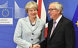 British Prime Minister Theresa May (L) is welcomed by European Commission Jean-Claude Juncker at European Commission in Brussels on December 8, 2017. (AFP PHOTO / EMMANUEL DUNAND)