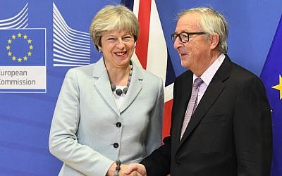 British Prime Minister Theresa May (L) is welcomed by European Commission Jean-Claude Juncker at European Commission in Brussels on December 8, 2017. (AFP PHOTO / EMMANUEL DUNAND)