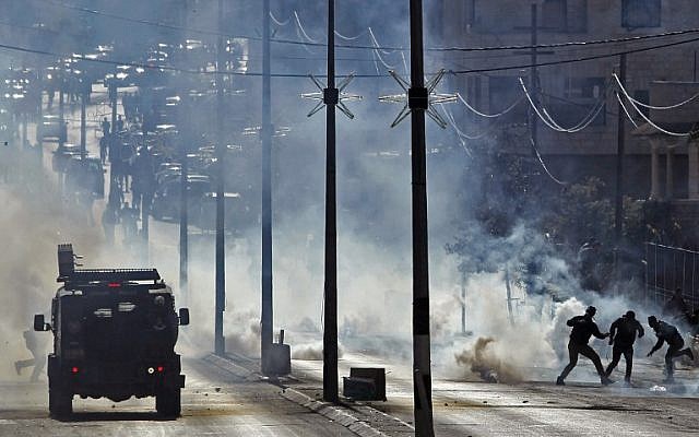 Palestinian protestors clash with Israeli security forces near a checkpoint in the West Bank city of Bethlehem on December 8, 2017. (Musa al-Shaer/AFP)