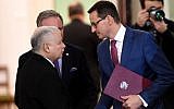Mateusz Morawiecki (R), newly designated as Poland's prime minister, shakes hands with the leader of the PiS (Law and Justice) party Jaroslaw Kaczynski at the presidential palace in Warsaw on December 8, 2017.(AFP Photo/ Janek Skarzynski)