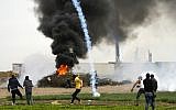 A picture taken on December 10, 2017 shows a tear gas canister falling amid Palestinian protesters during clashes with Israeli forces near the Israel-Gaza border east of the southern Gaza Strip city of Khan Younis. (MAHMUD HAMS/AFP)