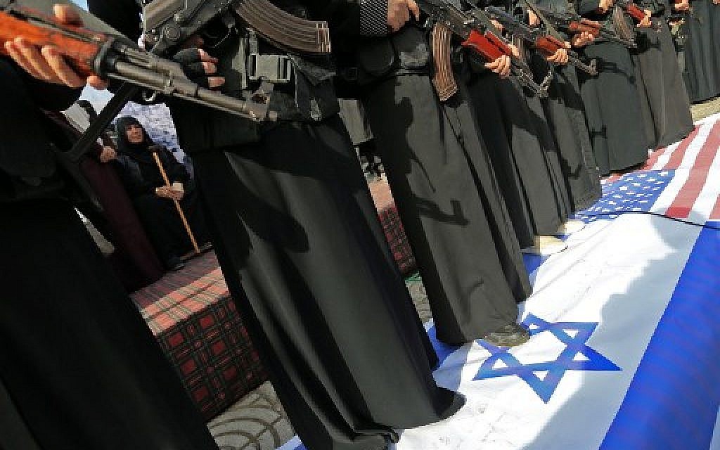 Armed female members of the Palestinian terrorist group Islamic Jihad carry Kalashnikov assault rifles while standing over banners depicting the Israeli and US flags, as they take part in a rally to protest against US President Donald Trump's decision to recognise Jerusalem as the capital of Israel, in Gaza City on December 11, 2017. (AFP PHOTO / MOHAMMED ABED)
