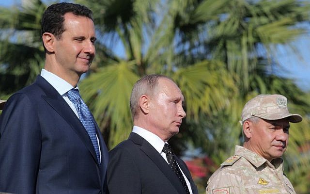 Syrian President Bashar al-Assad, left, Russian President Vladimir Putin, center, and Russian Defense Minister Sergei Shoigu inspect a military parade during their visit to the Russian air base in Hmeimim in the northwestern Syrian province of Latakia, December 11, 2017. (Mikhail Klimentyev/AFP) Syrian President Bashar al-Assad, left, Russian President Vladimir Putin, center, and Russian Defense Minister Sergei Shoigu inspect a military parade during their visit to the Russian air base in Hmeimim in the northwestern Syrian province of Latakia, December 11, 2017. (Mikhail Klimentyev/AFP)