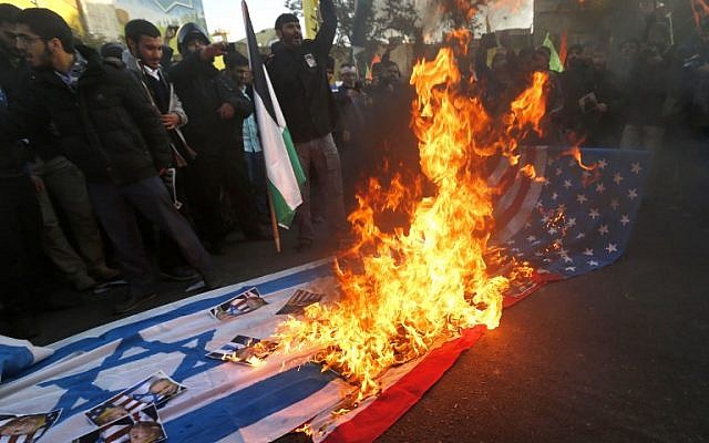 Iranian protesters set US and Israeli flags on fire during a demonstration in the capital Tehran to denounce US President Donald Trump's declaration of Jerusalem as Israel's capital, December 11, 2017. (ATTA KENARE/AFP) Iranian protesters set US and Israeli flags on fire during a demonstration in the capital Tehran to denounce US President Donald Trump's declaration of Jerusalem as Israel's capital, December 11, 2017. (ATTA KENARE/AFP)