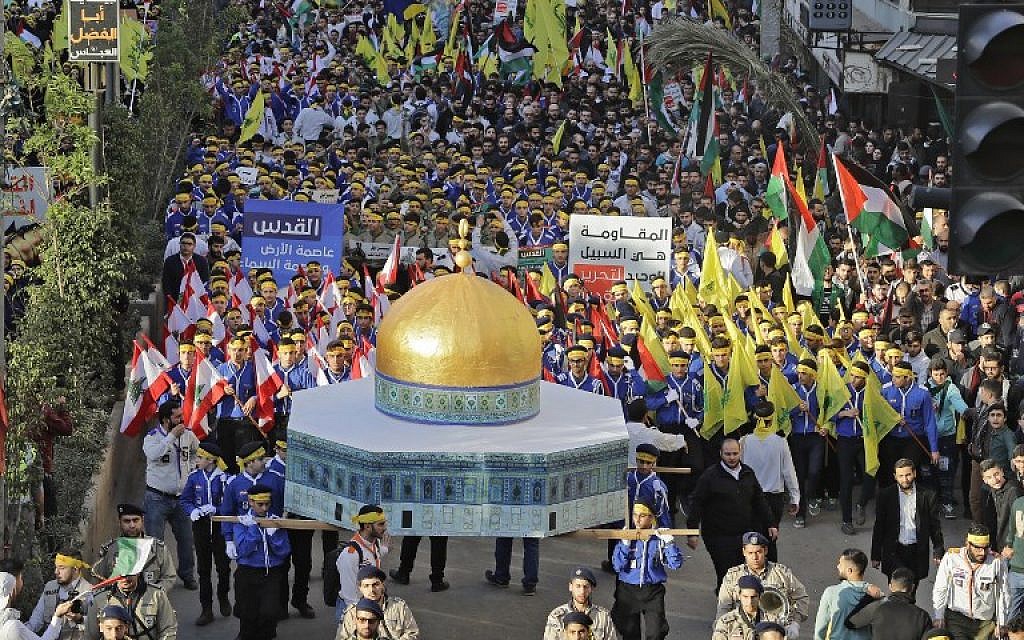 Supporters of Lebanon's Hezbollah terror group march with a model of the Dome of the Rock and wave Lebanese, Palestinian and Hezbollah flags during a protest in Beirut on December 11, 2017. (AFP Photo/Joseph Eid)