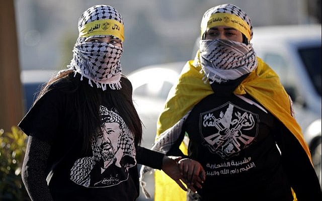 Masked female Palestinian protesters with shirts and flags of PA President Mahmoud Abbas' Fatah party are seen during a demonstration in the West Bank city of Ramallah on December 11, 2017. (AFP Photo/Thomas Coex) Masked female Palestinian protesters with shirts and flags of PA President Mahmoud Abbas' Fatah party are seen during a demonstration in the West Bank city of Ramallah on December 11, 2017. (AFP Photo/Thomas Coex)
