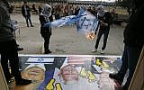 Palestinians burn Israeli flags next to a poster bearing images of US President Donald Trump (R), US Vice President Mike Pence (C), and Prime Minister Benjamin Netanyahu, during a demonstration at the al-Quds Open University in Dura, a village on the outskirts of the West Bank city of Hebron, on December 13, 2017.(AFP Photo/Hazem Bader)