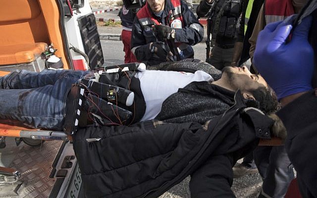 A Palestinian man, wearing a suspected suicide vest, is carried into an ambulance after he stabbed a soldier and was then shot in the West Bank town of al-Bireh on December 15, 2017. (Oren Ziv/AFP) A Palestinian man, wearing a suspected suicide vest, is carried into an ambulance after he stabbed a soldier and was then shot in the West Bank town of al-Bireh on December 15, 2017. (Oren Ziv/AFP)