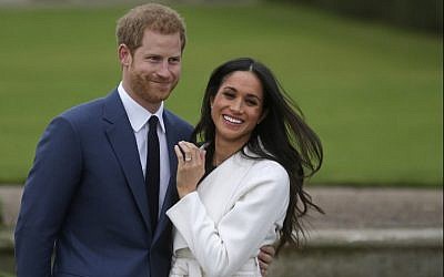 This file photo taken on November 27, 2017, shows Britain's Prince Harry standing with his fiancée US actress Meghan Markle as she shows off her engagement ring whilst they pose for a photograph in the Sunken Garden at Kensington Palace in London. (AFP Photo/Daniel Leal-Olivas)